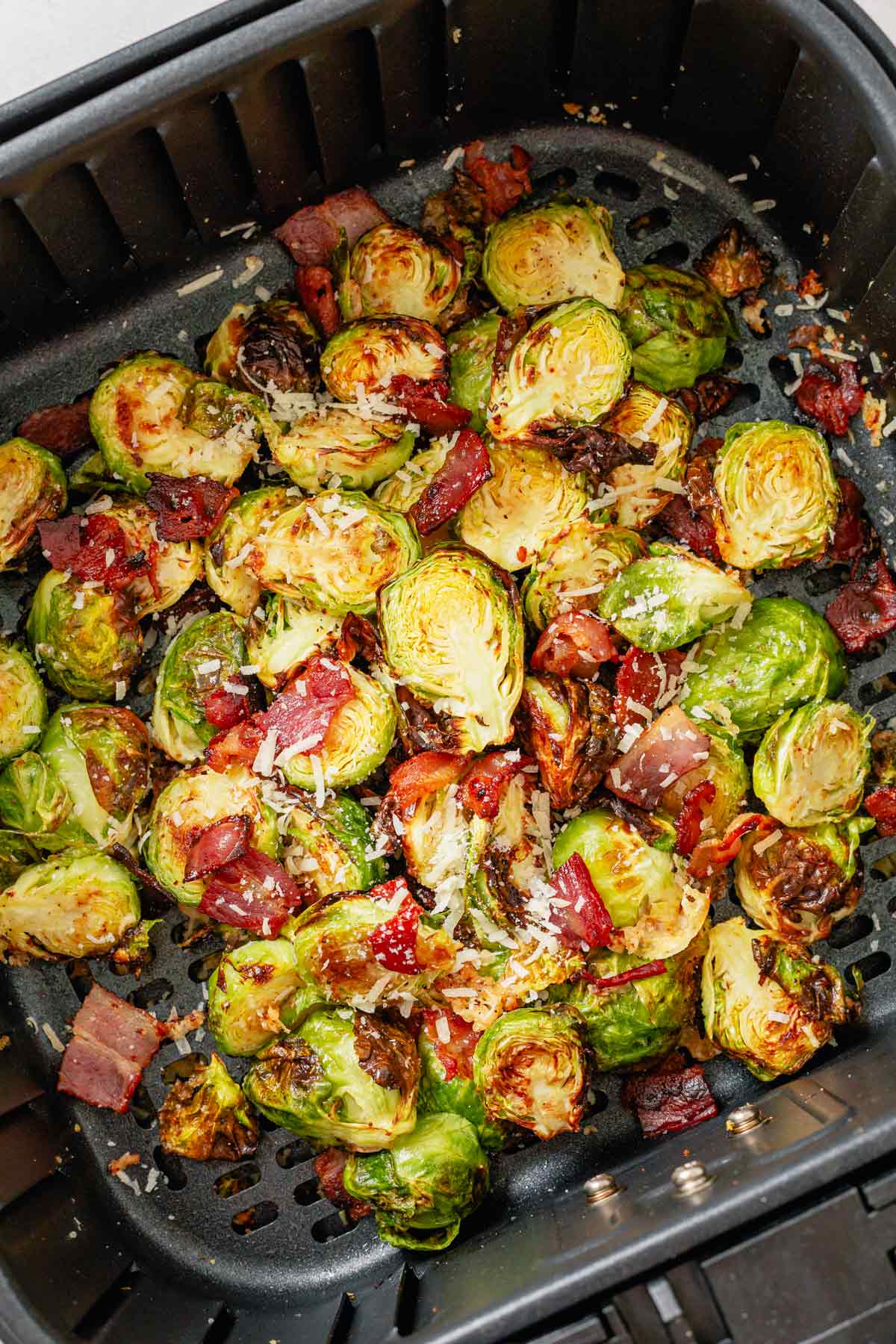 brussel sprouts in air frier basket with bacon and parmesan