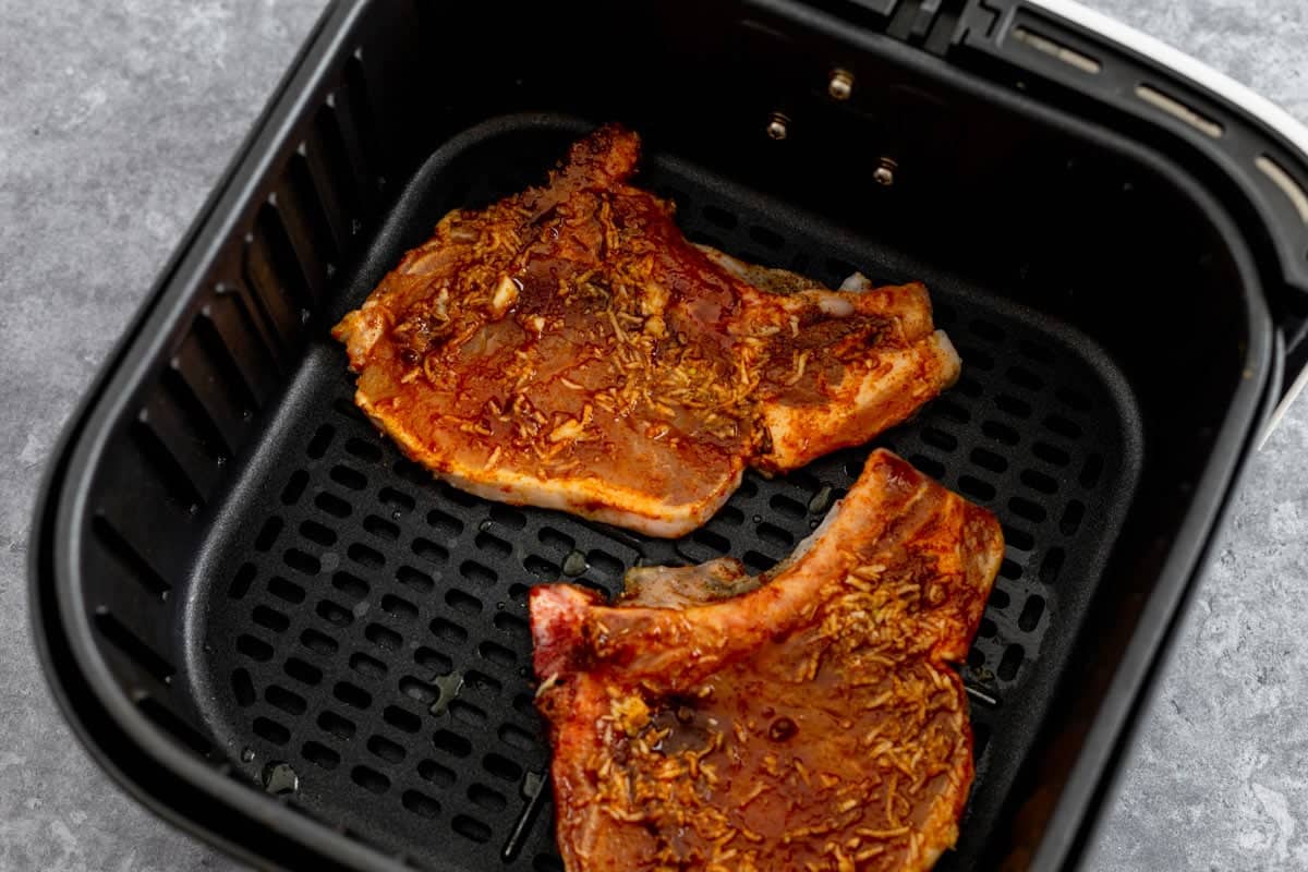 raw seasoned pork chops in air fryer basket