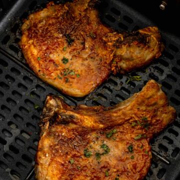 cooked bone in pork chops in a bowl with broccoli