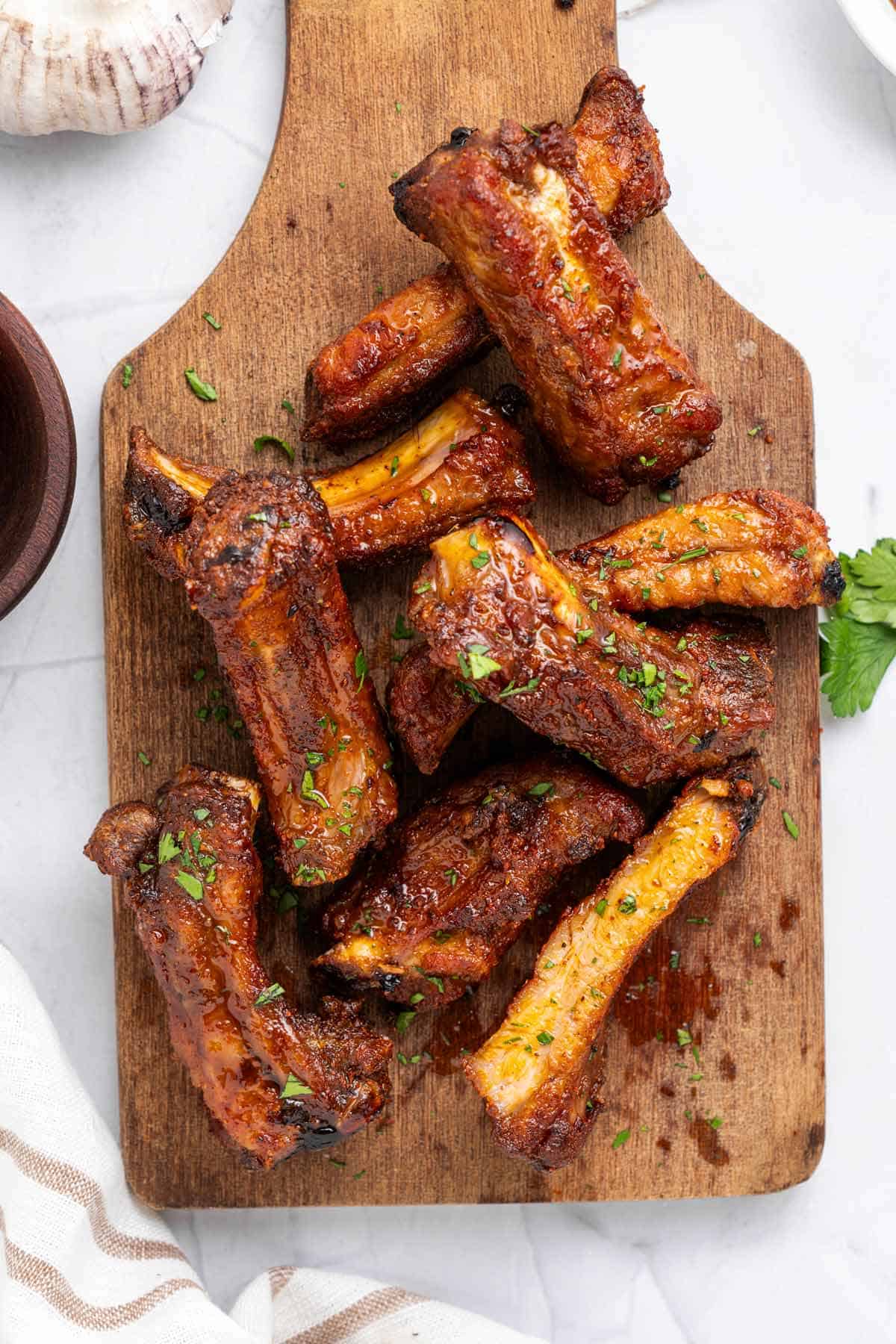 cooked air fryer ribs on wooden board.