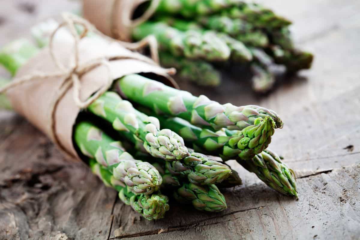 bright asparagus stalks wrapped in brown paper with ribbon.