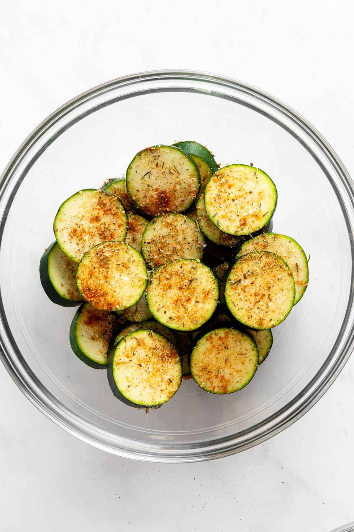 seasoned zucchini slices in a bowl.