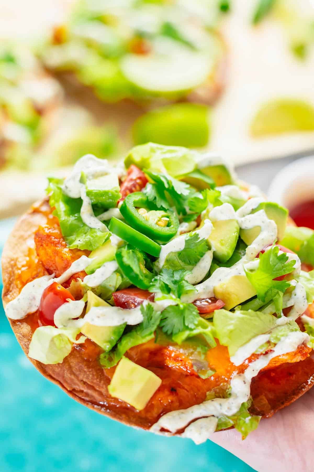 crispy tostadas with buffalo chicken toppings and ranch dressing close up shot