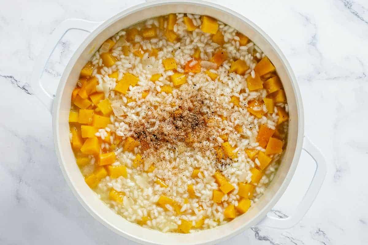 pumpkin risotto ingredients simemring in a white dutch oven