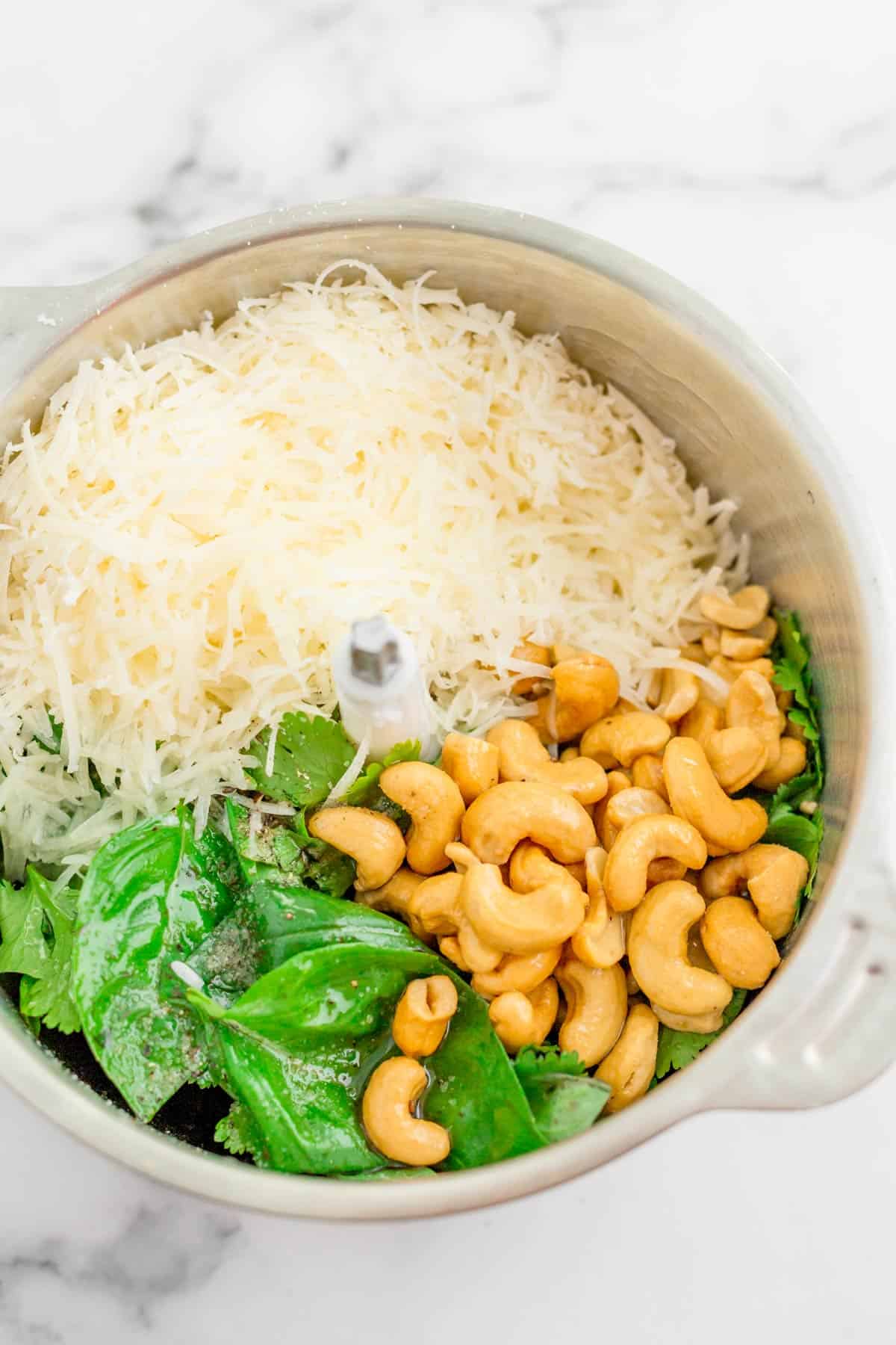 parmesan, cashew and basil leaves ina food processor before blending into pesto