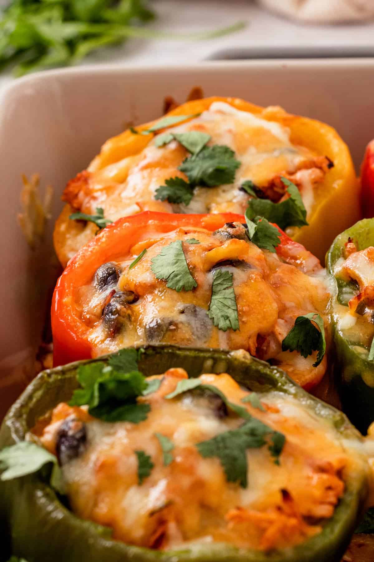 baked stuffed peppers with cilantro in a baking dish