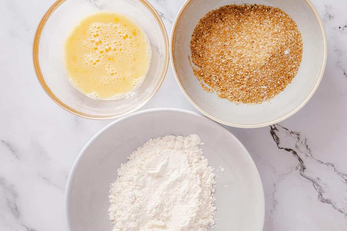 ingredients in three bowls for breaded chicken