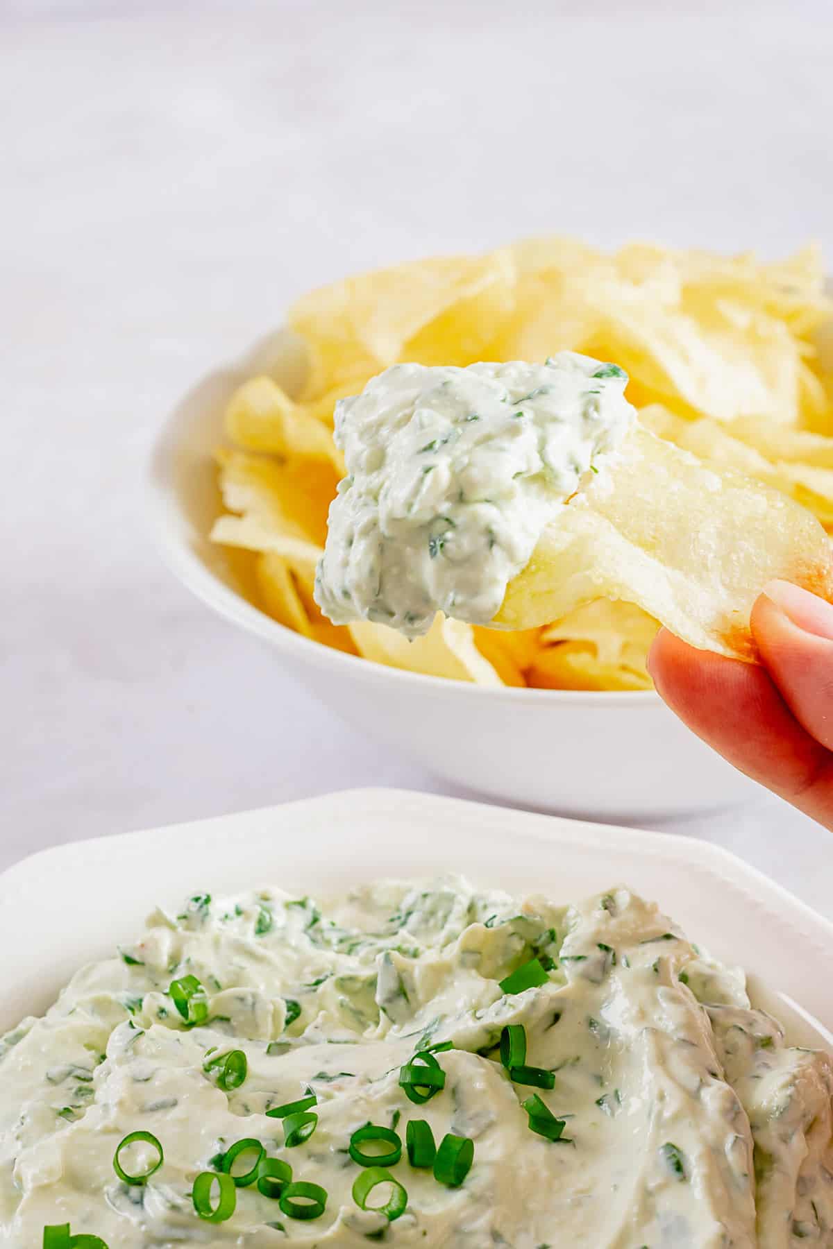 chips dunked into creamy cold spinach dip