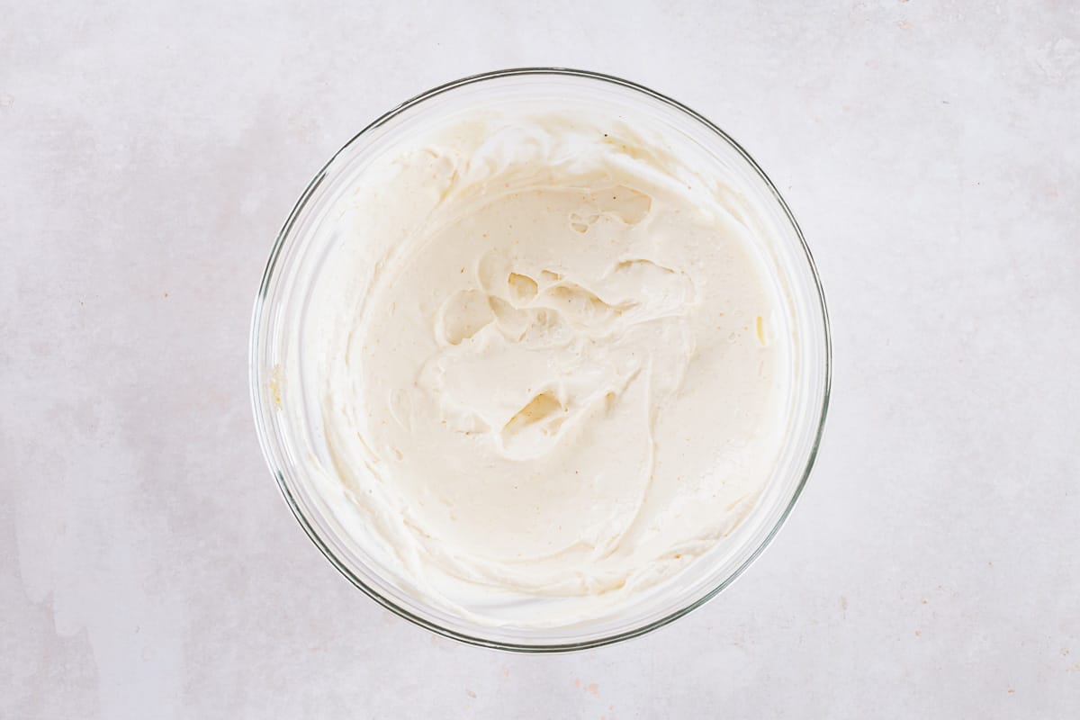 cream cheese and yogurt mixed in a bowl for spinach dip