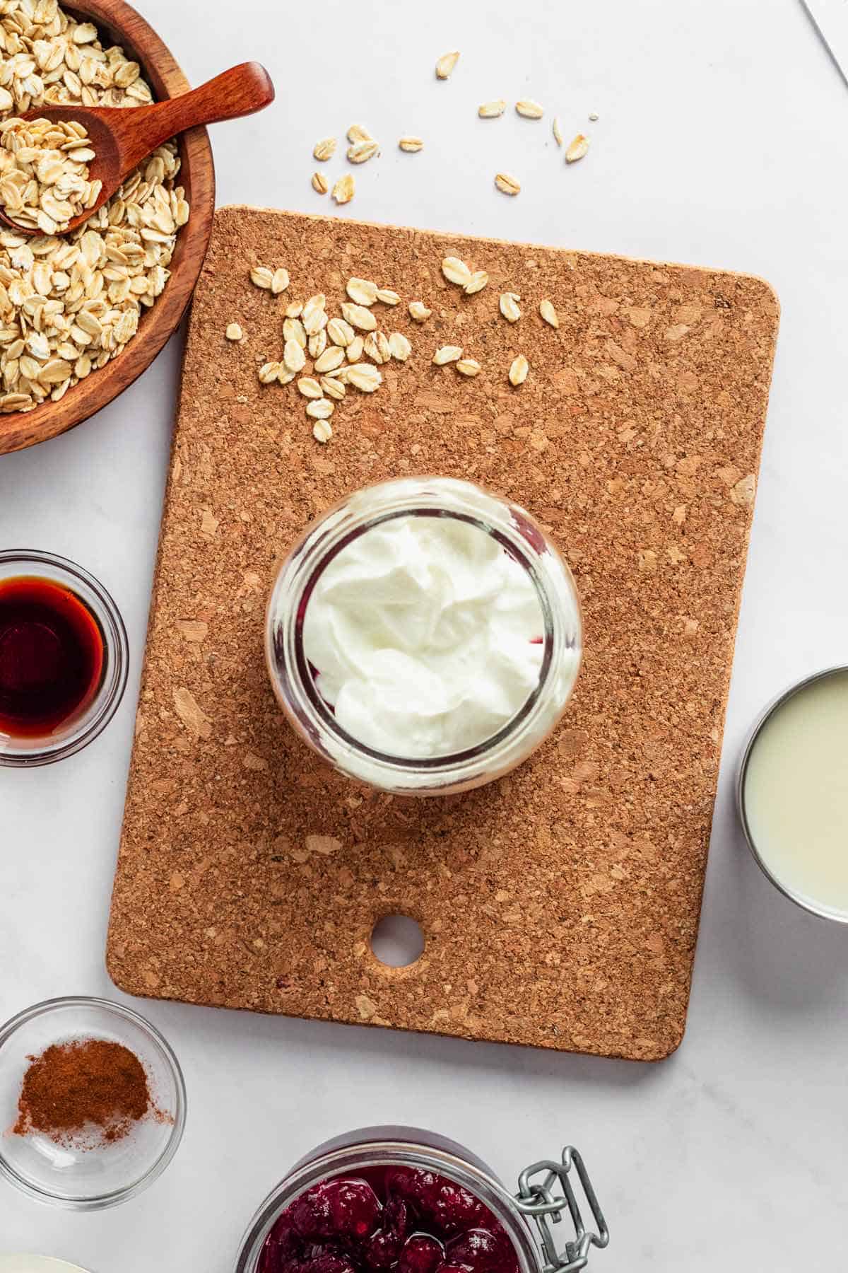 adding yogurt to the jar with overnight oats.