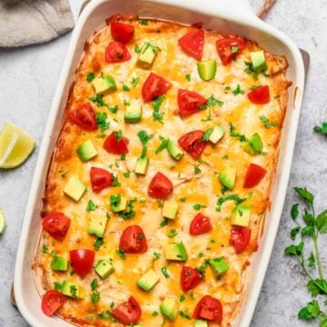 chicken enchilada casserole with tomatoes, avocado and cilantro