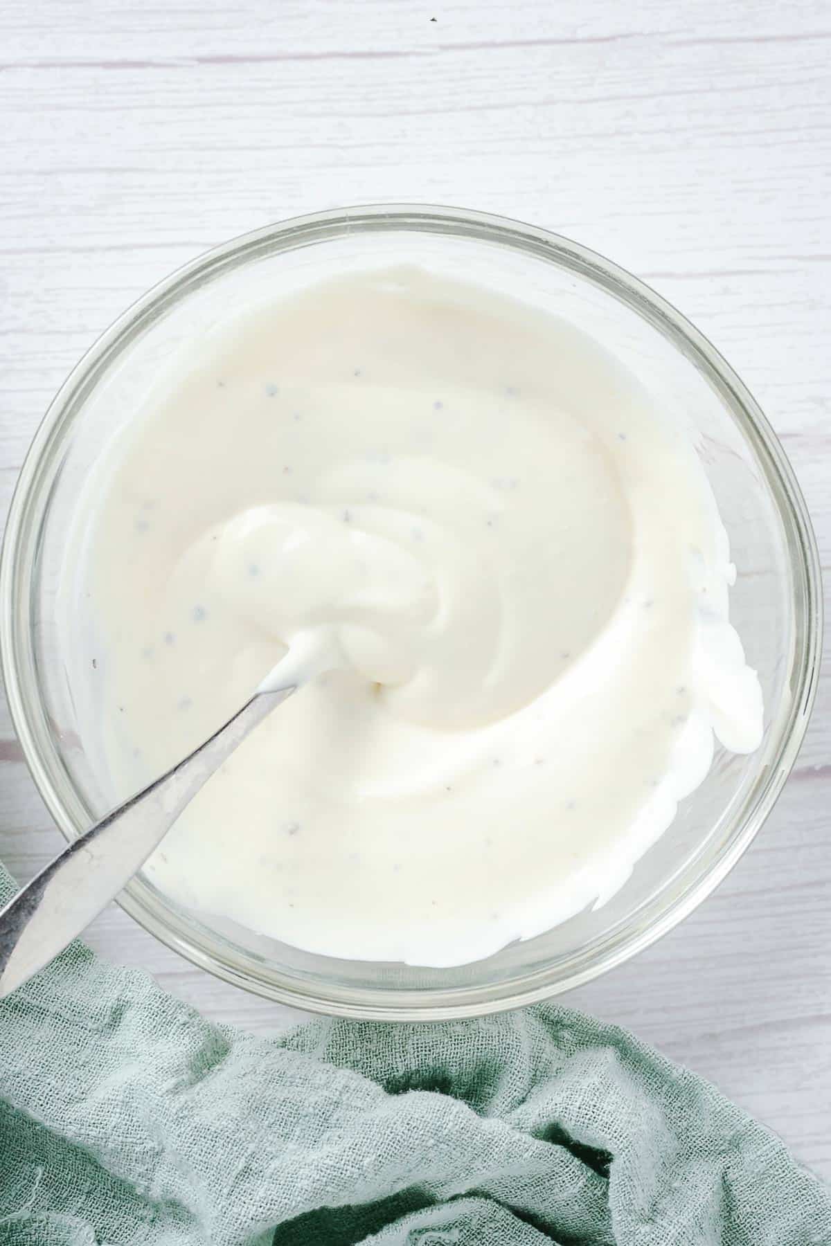 mayonnaise dressing in a glass bowl for cucumber salad