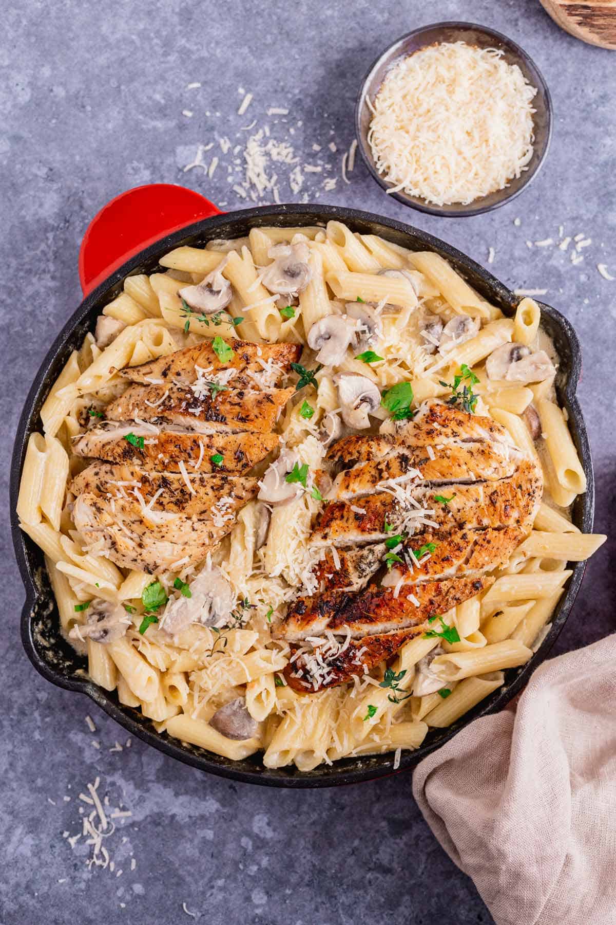 creamy garlic chicken and mushroom pasta in a black skillet