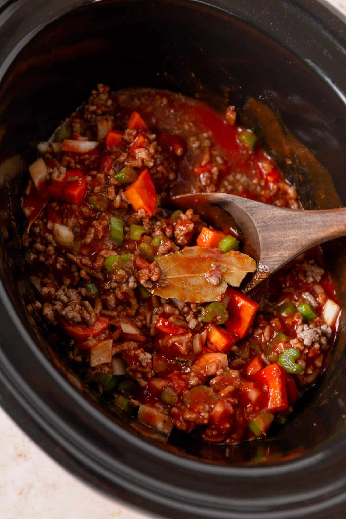 vegetables, tomato sauce and seasonings in slow cooker before cooking