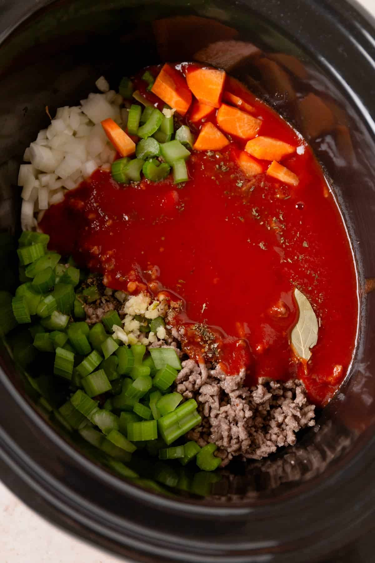 vegetables and tomato sauce in slow cooker before cooking