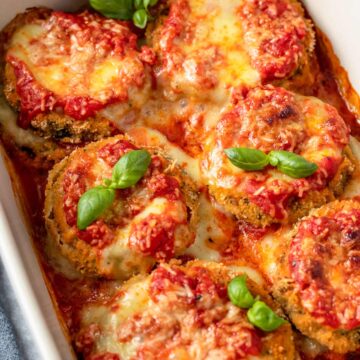 Gluten Free Eggplant Parmesan in baking dish with basil leaves