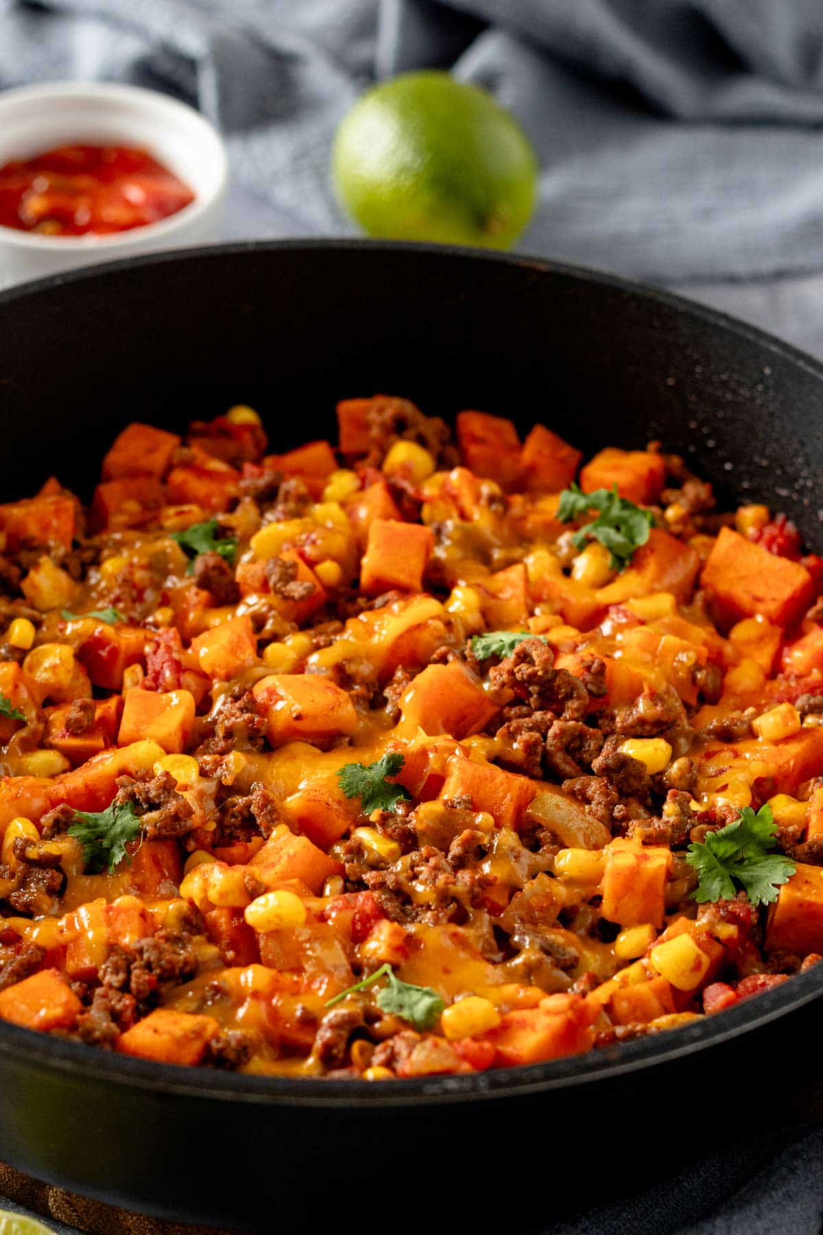 ground beef and sweet potatoes in skillet with cheese.