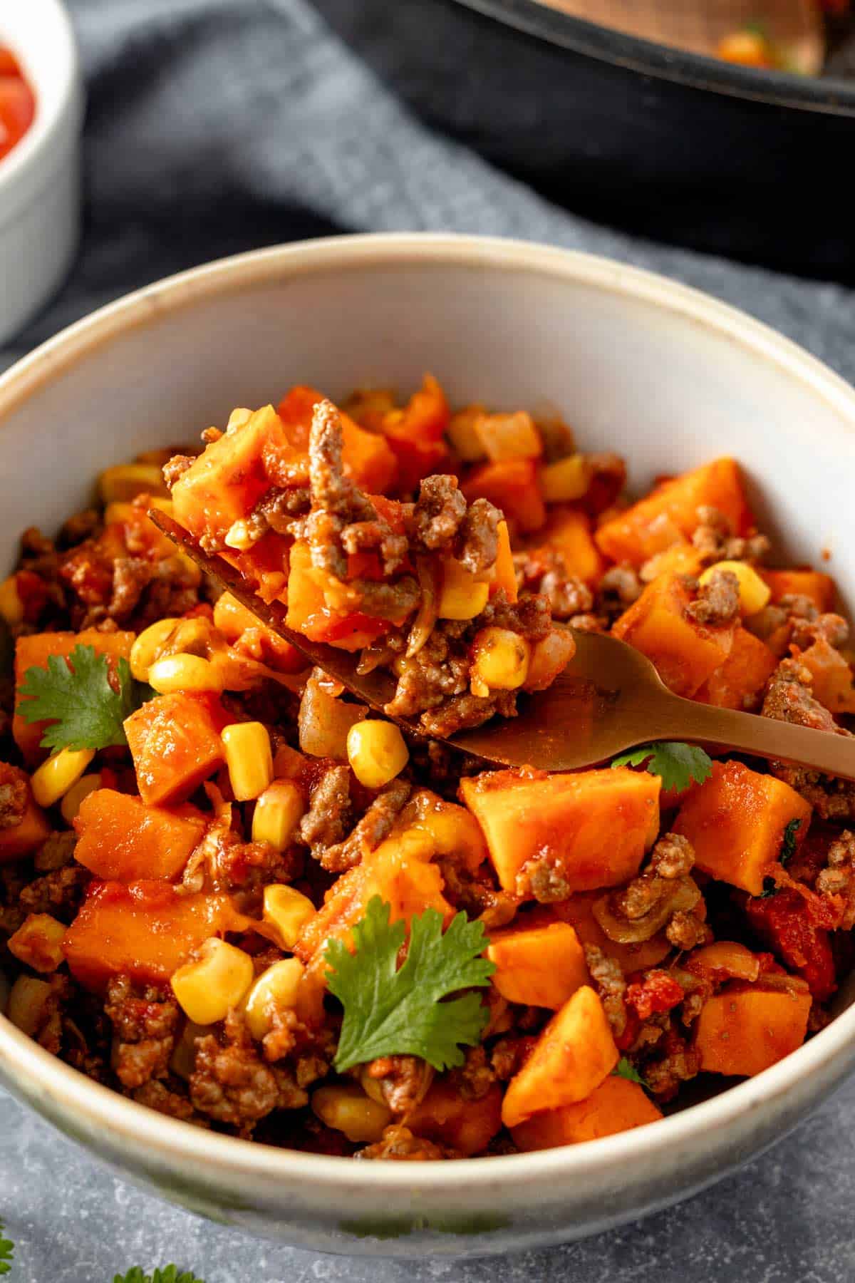 ground beef and sweet potatoes in a bowl with cheese.