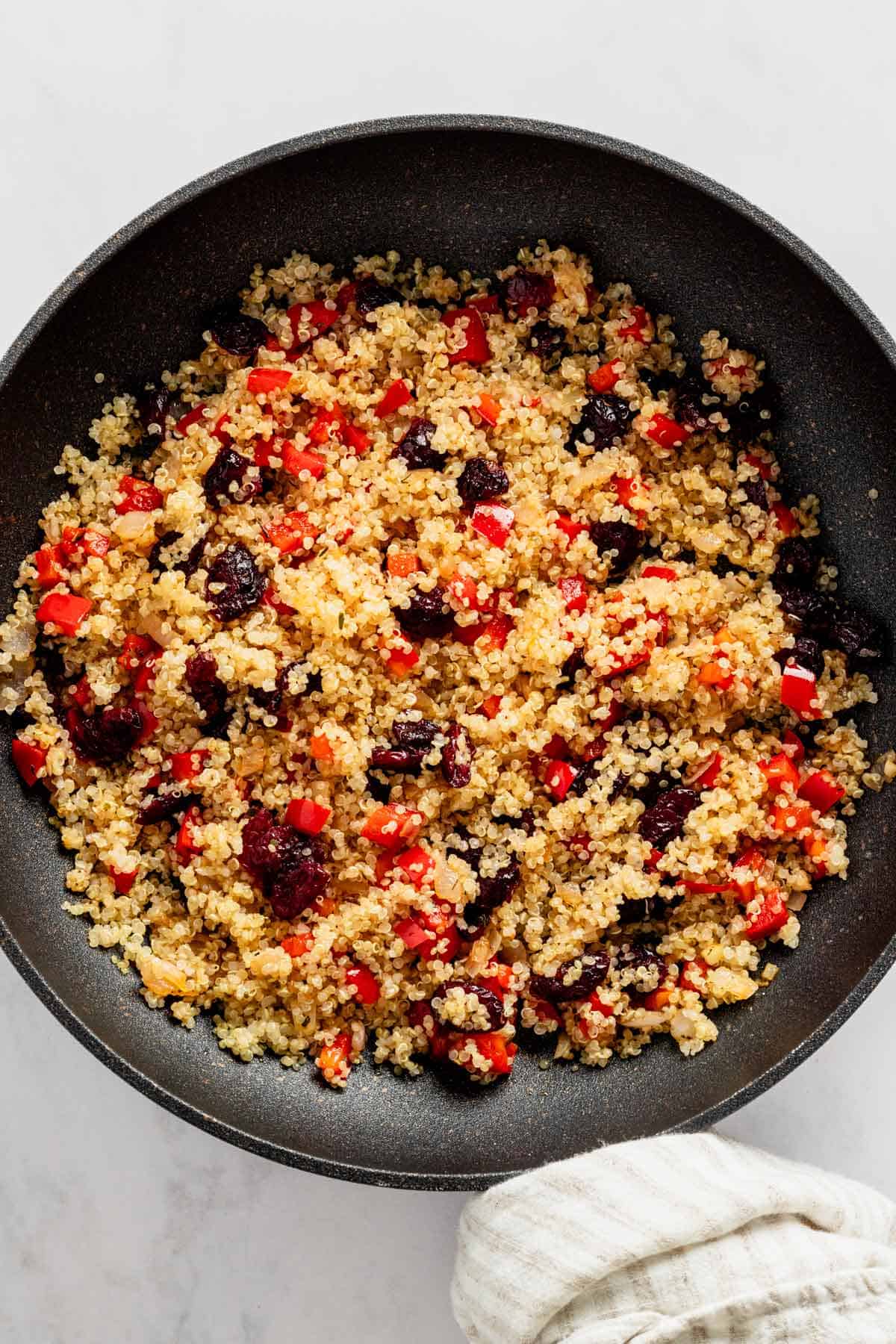 quinoa with bell peppers and cranberry in skillet.