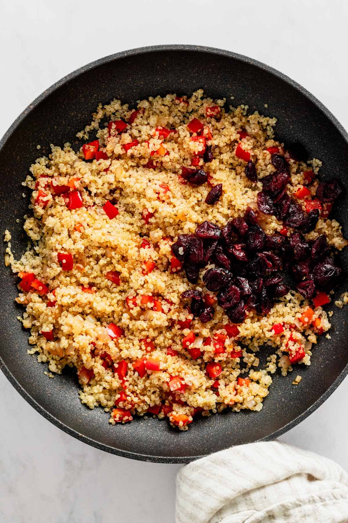 quinoa with bell peppers and cranberry in skillet.