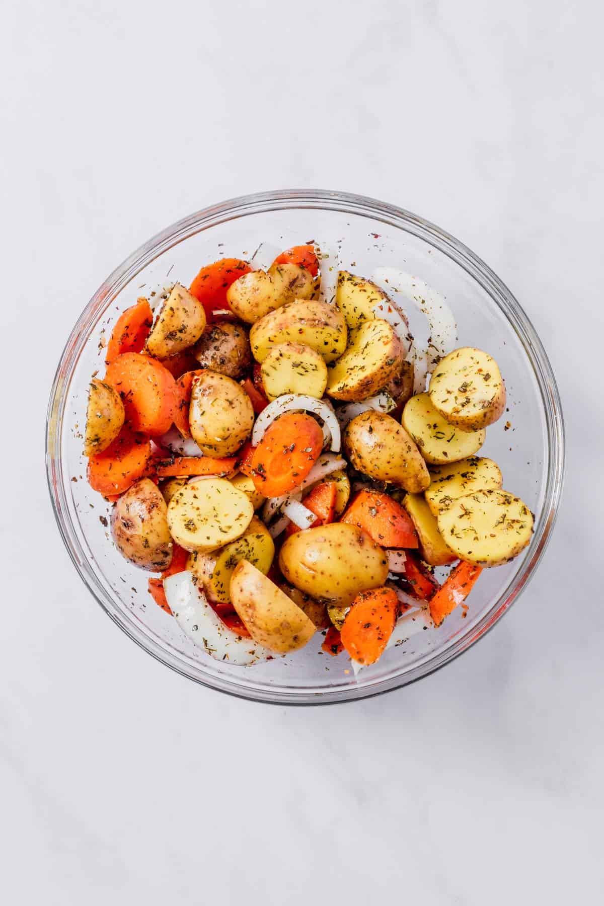 carrots, potatoes and onion mixed with seasonings and oil