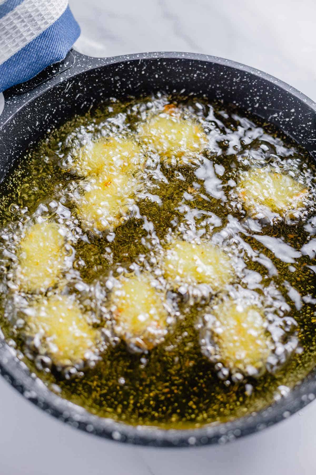 tater tots frying in a pan