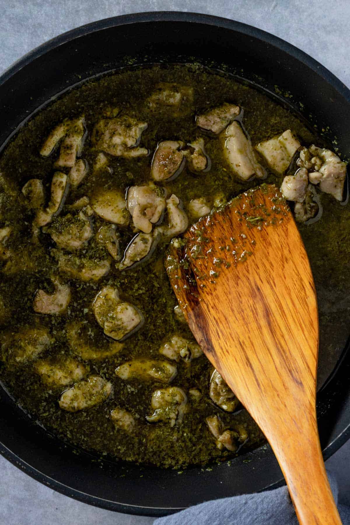 chicken cooking in pesto sauce