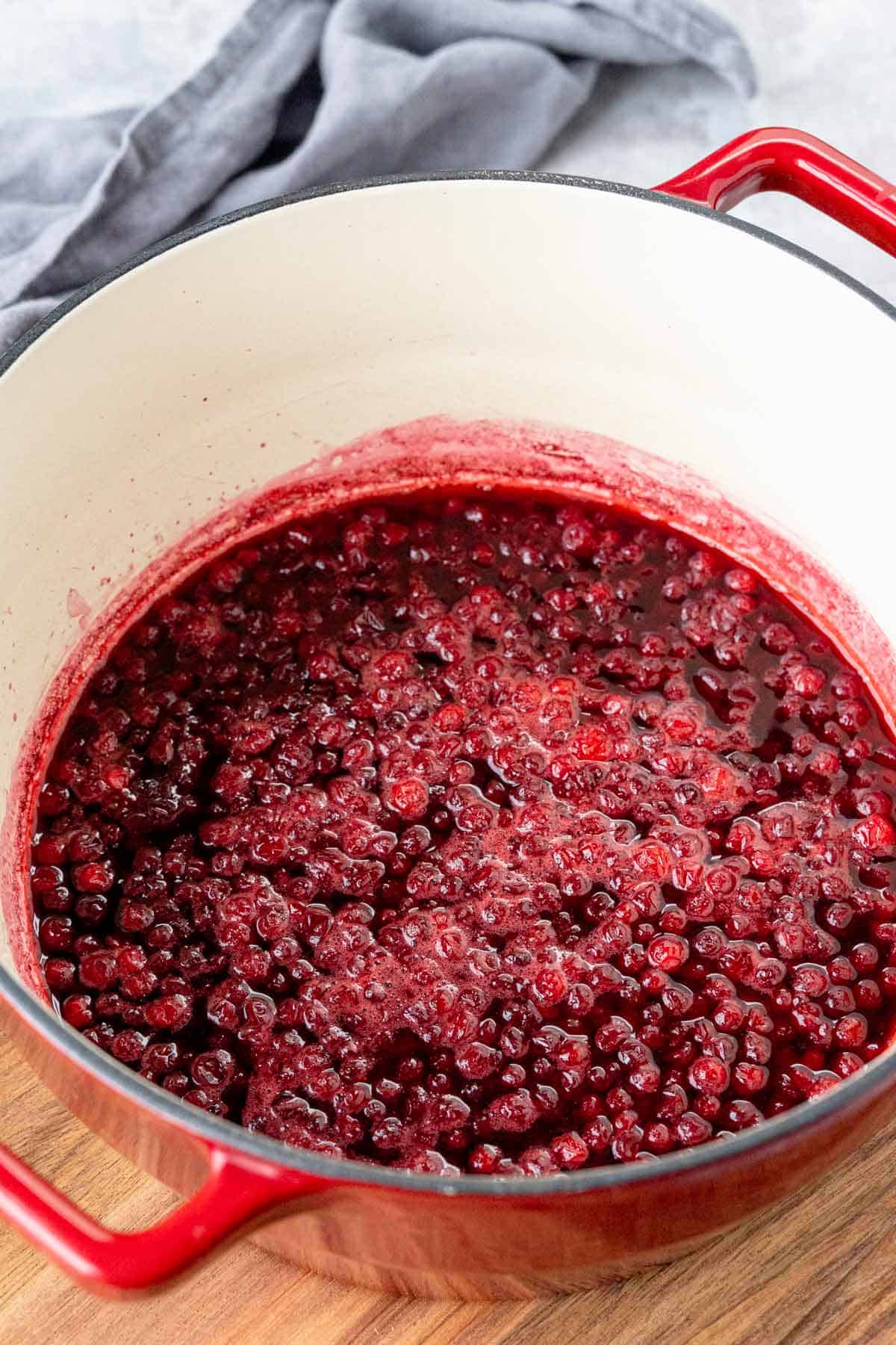 cooking lingonberries in a pot.