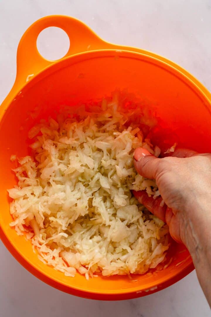 massaging cabbage to remove excess liquid.