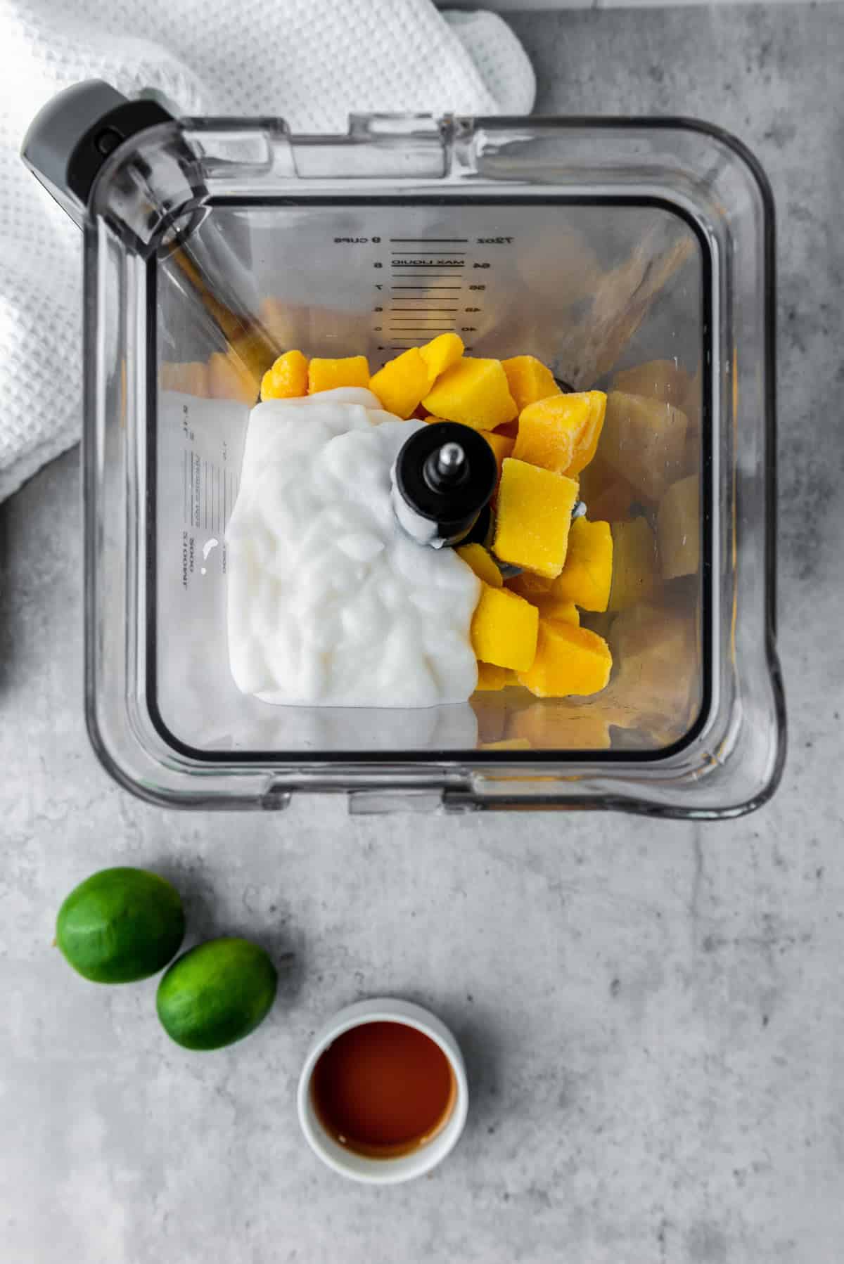 coconut yogurt and mangoes in food processor before blending