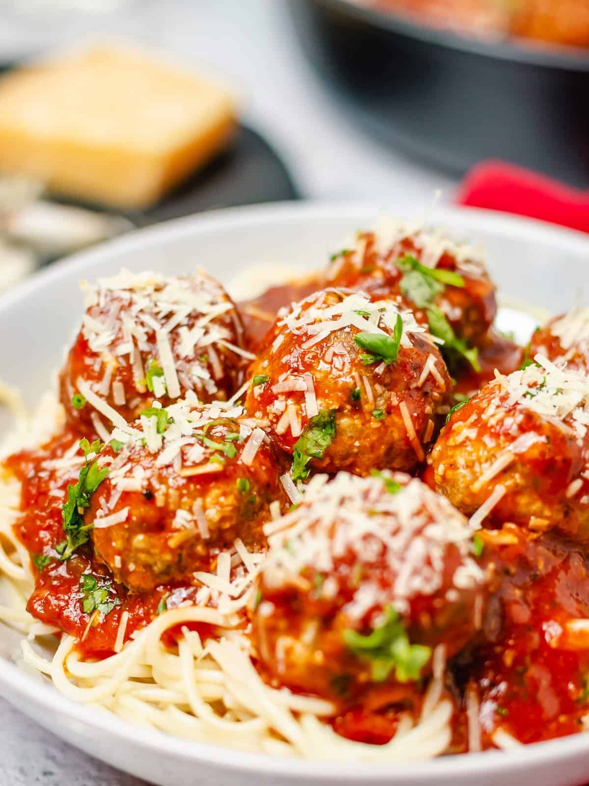 stacked meatballs in tomato sauce on a pile of spaghetti