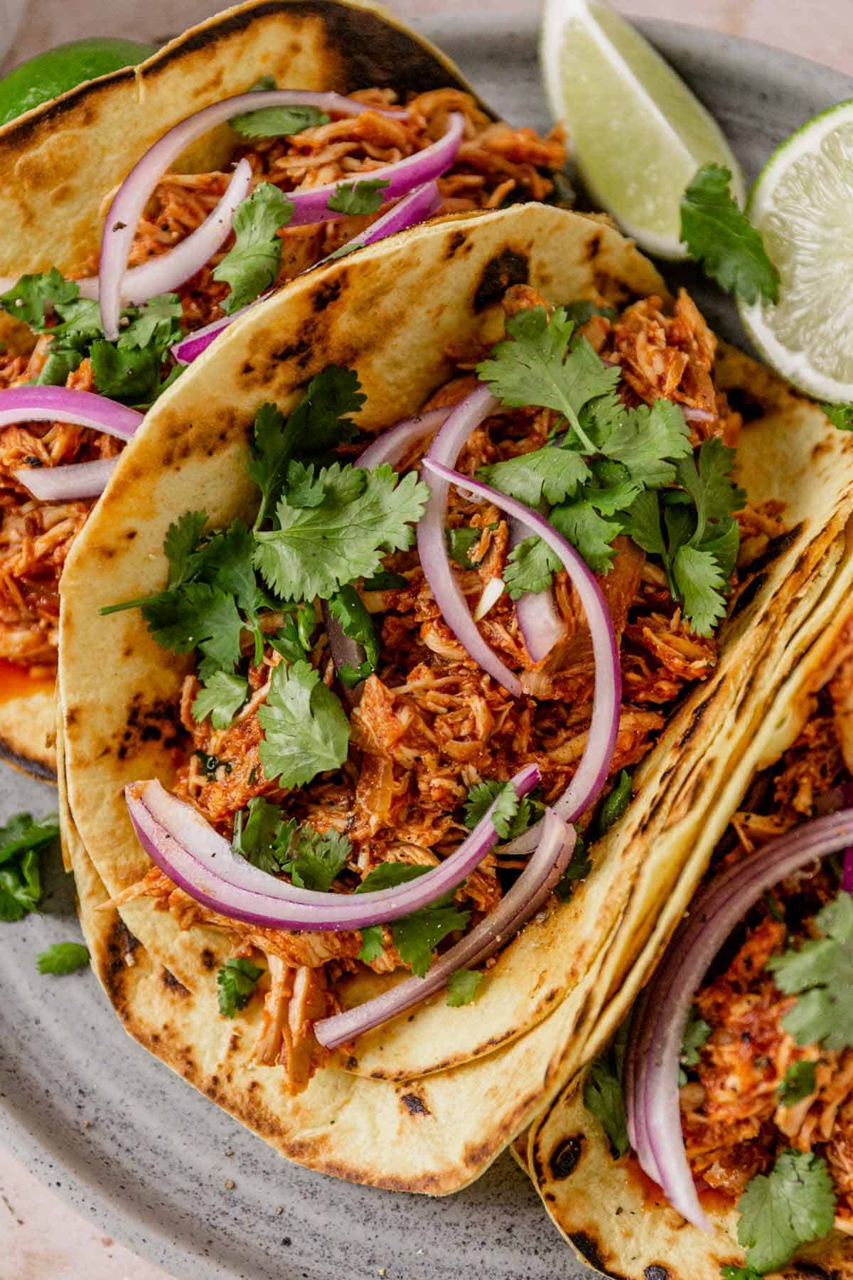 chicken tinga tacos with onion and cilantro on a plate