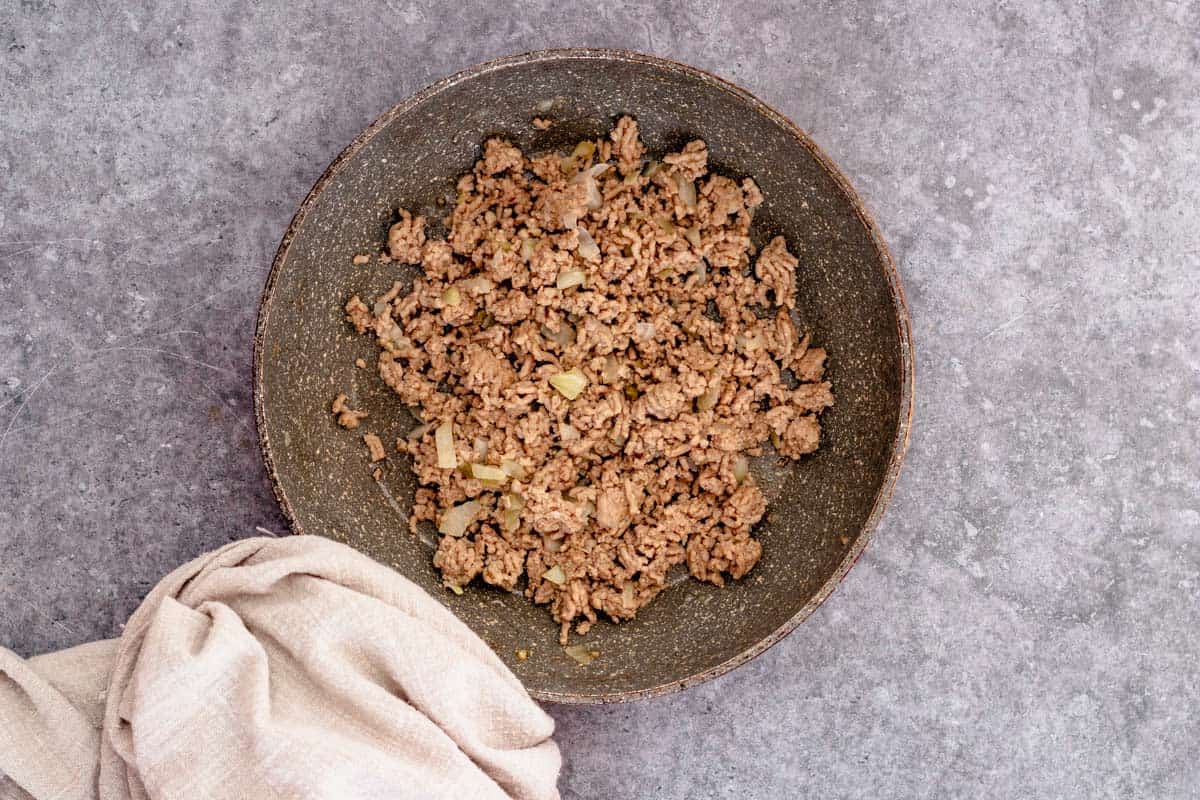 browning beef and onion in a skillet for taco soup