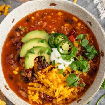 slow cooker taco soup with beef in bowl with toppings