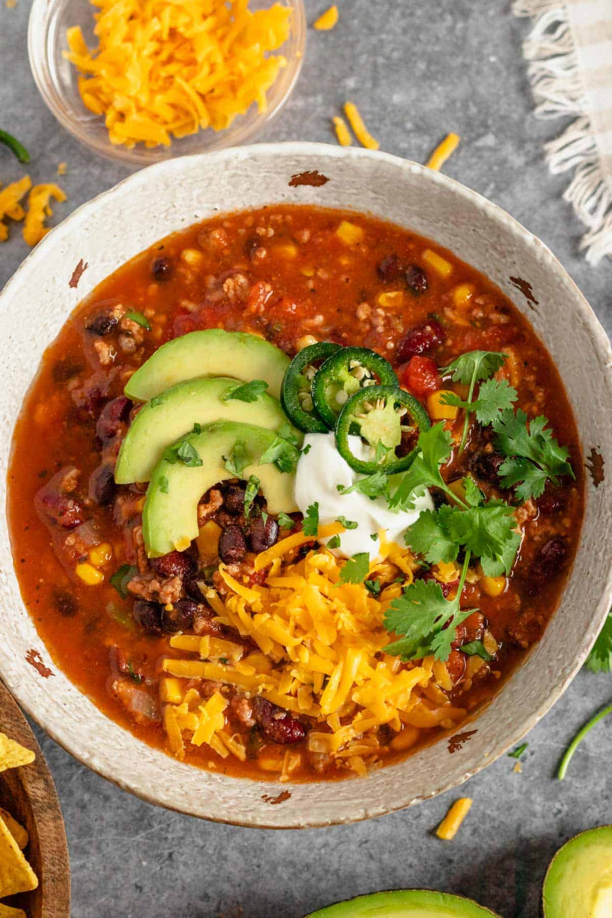 slow cooker taco soup with beef in bowl with toppings