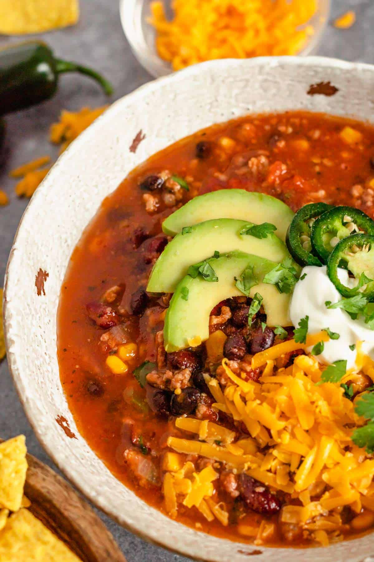 slow cooker taco soup with beef in bowl with toppings