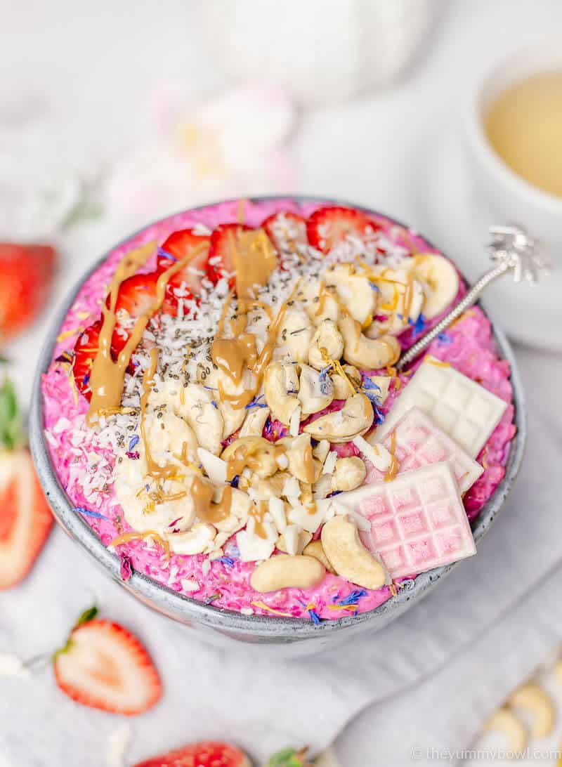 pink oatmeal porridge in a grey bowl with toppings