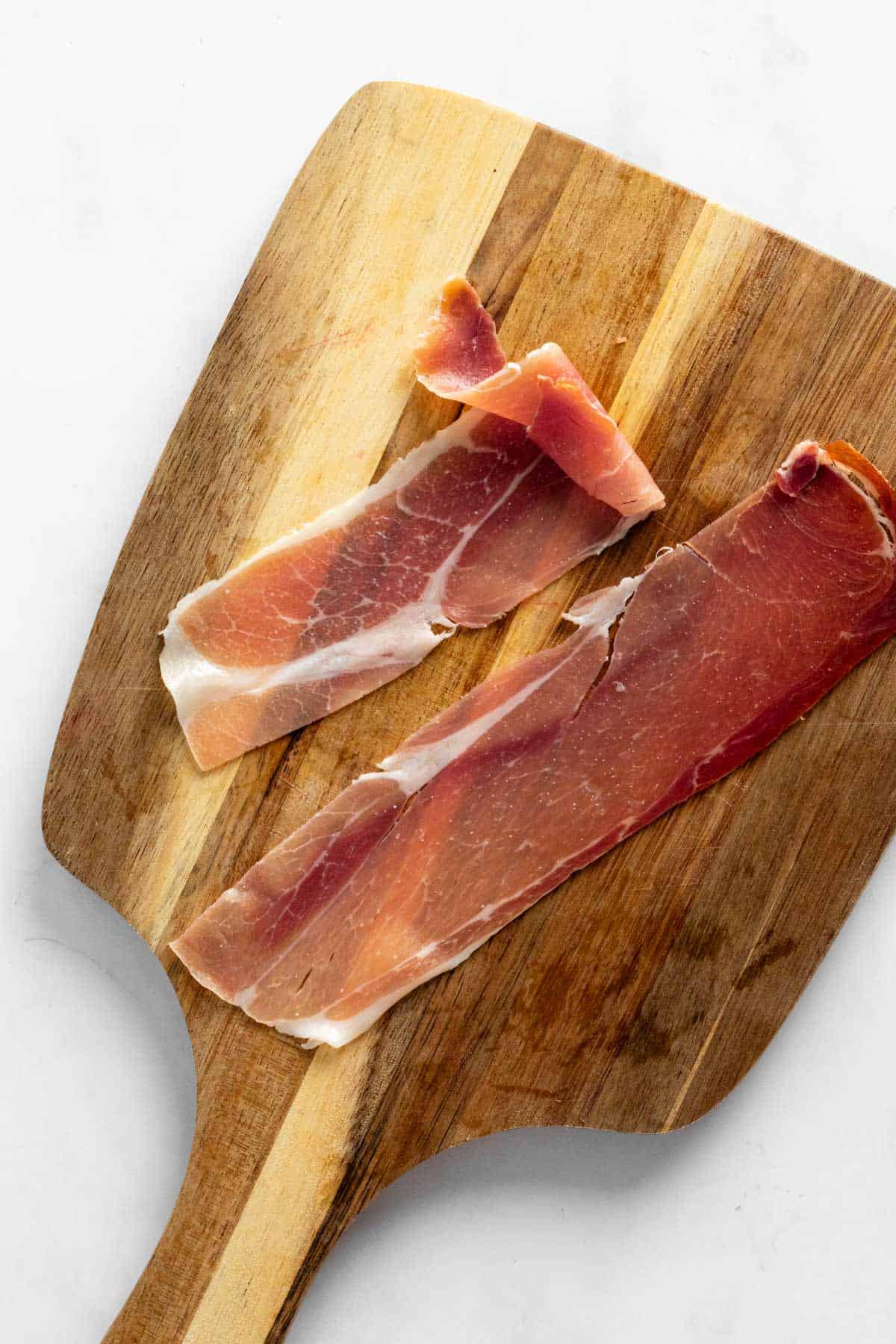 prosciutto slice on cutting board.