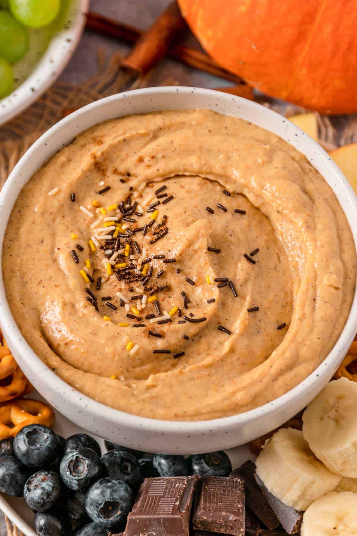 Pumpkin Cream Cheese Dip with pretzels, banana, chocolate, blueberries and apples