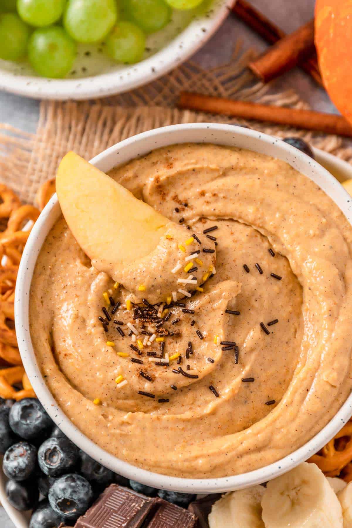 apple dipped into pumpkin cream cheese dip