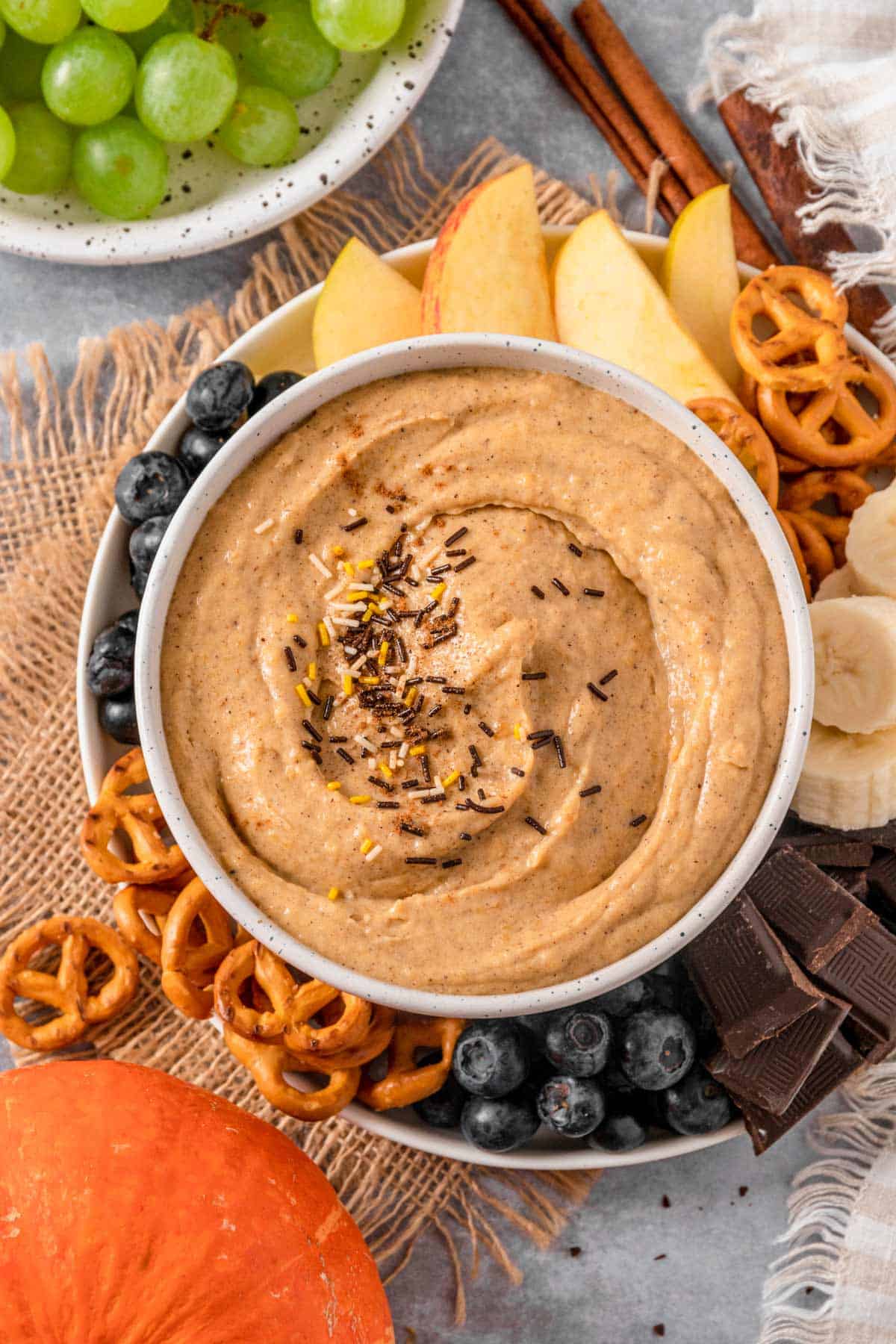 Pumpkin Cream Cheese Dip with pretzels, banana, chocolate, blueberries and apples