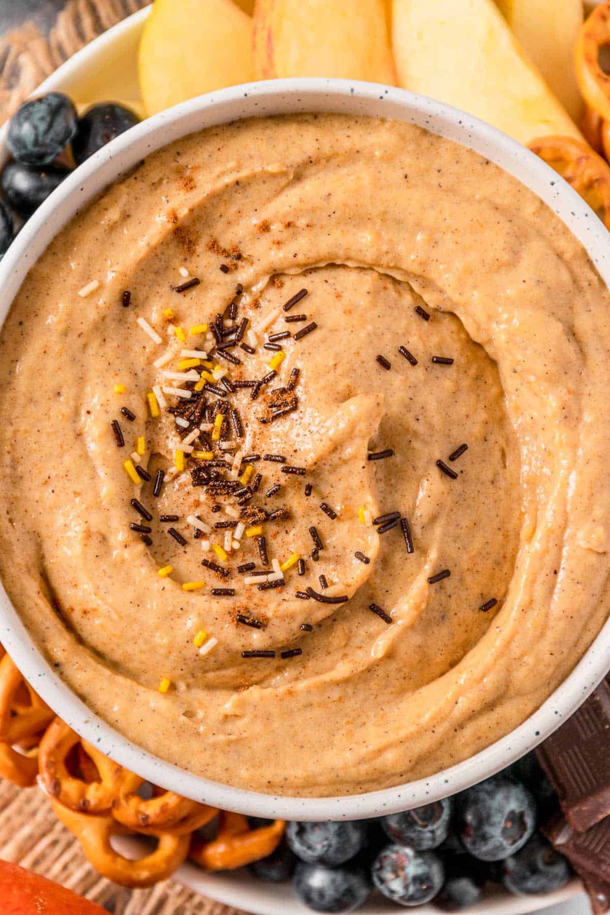 Pumpkin Cream Cheese Dip with pretzels, banana, chocolate, blueberries and apples