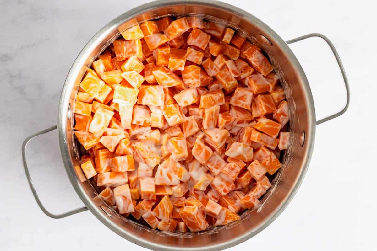 pumpkin cubes with coconut milk in a pot.