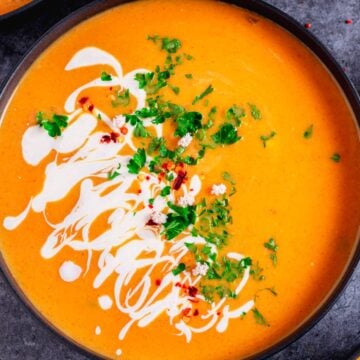 vegan pumpkin soup with cilantro and sour cream in a bowl