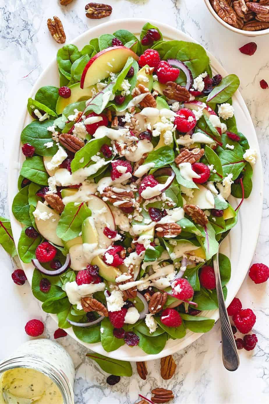 Raspberry, Spinach, and Beet Green Salad - healthy, summer salad recipe loaded with raspberries, pecans, fresh spinach, feta, and beet leaves. This recipe uses just a few ingredients and is simply delicious on its own. But what makes this salad unforgettably delicious is the Creamy Greek Yogurt Herb Dressing. - The Yummy Bowl