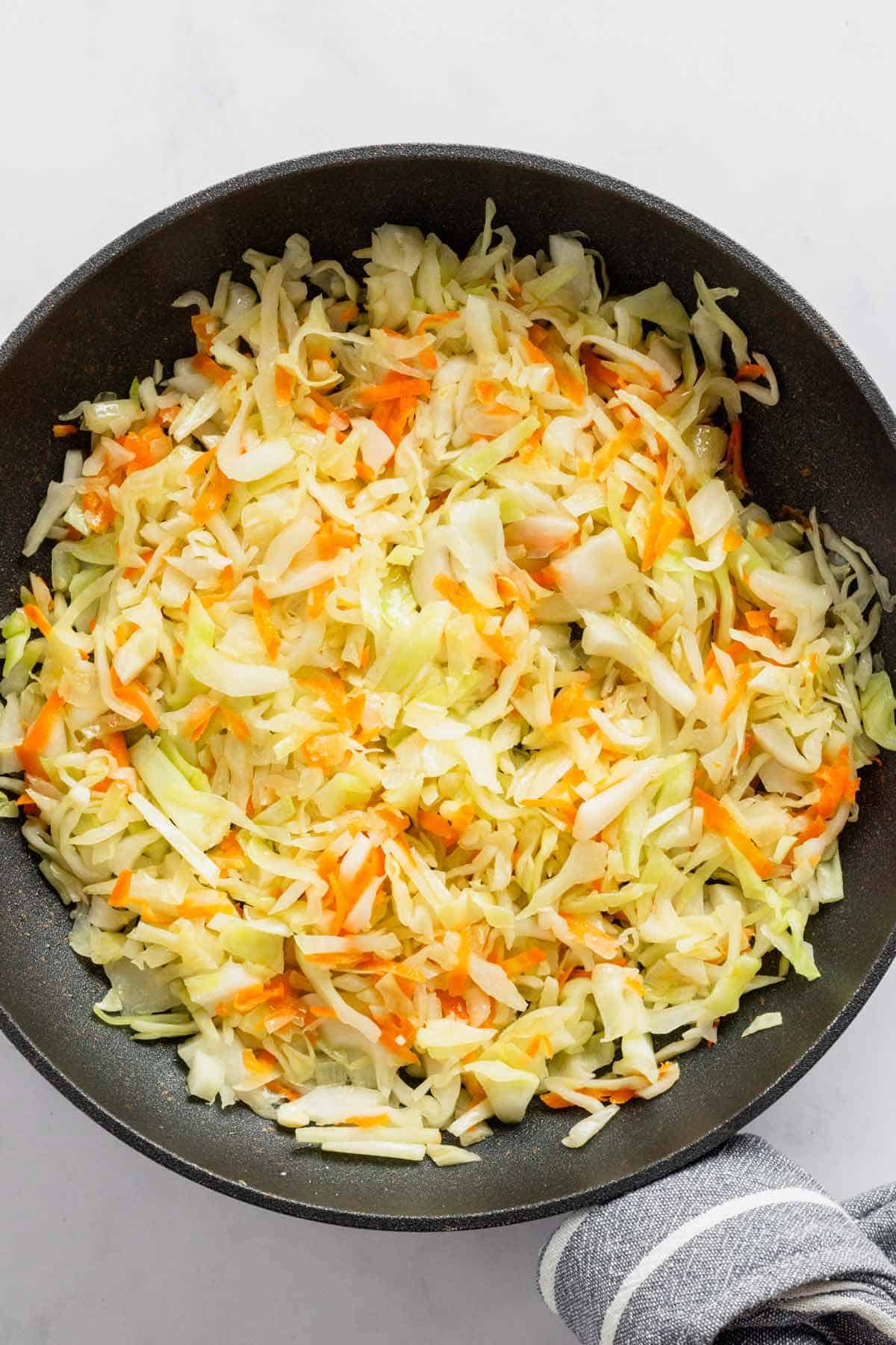 shredded cabbage added to skillet.