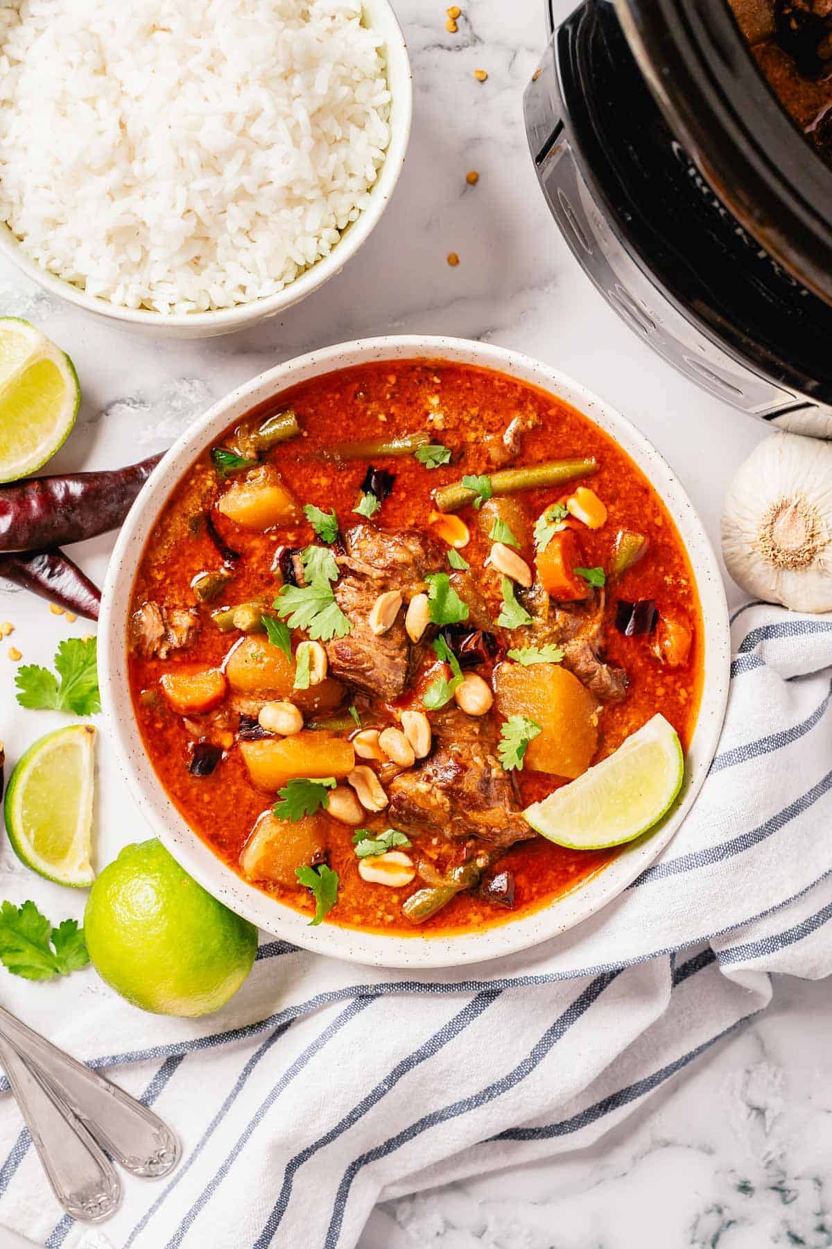 massaman beef curry with garnishes in a bowl ready for serving