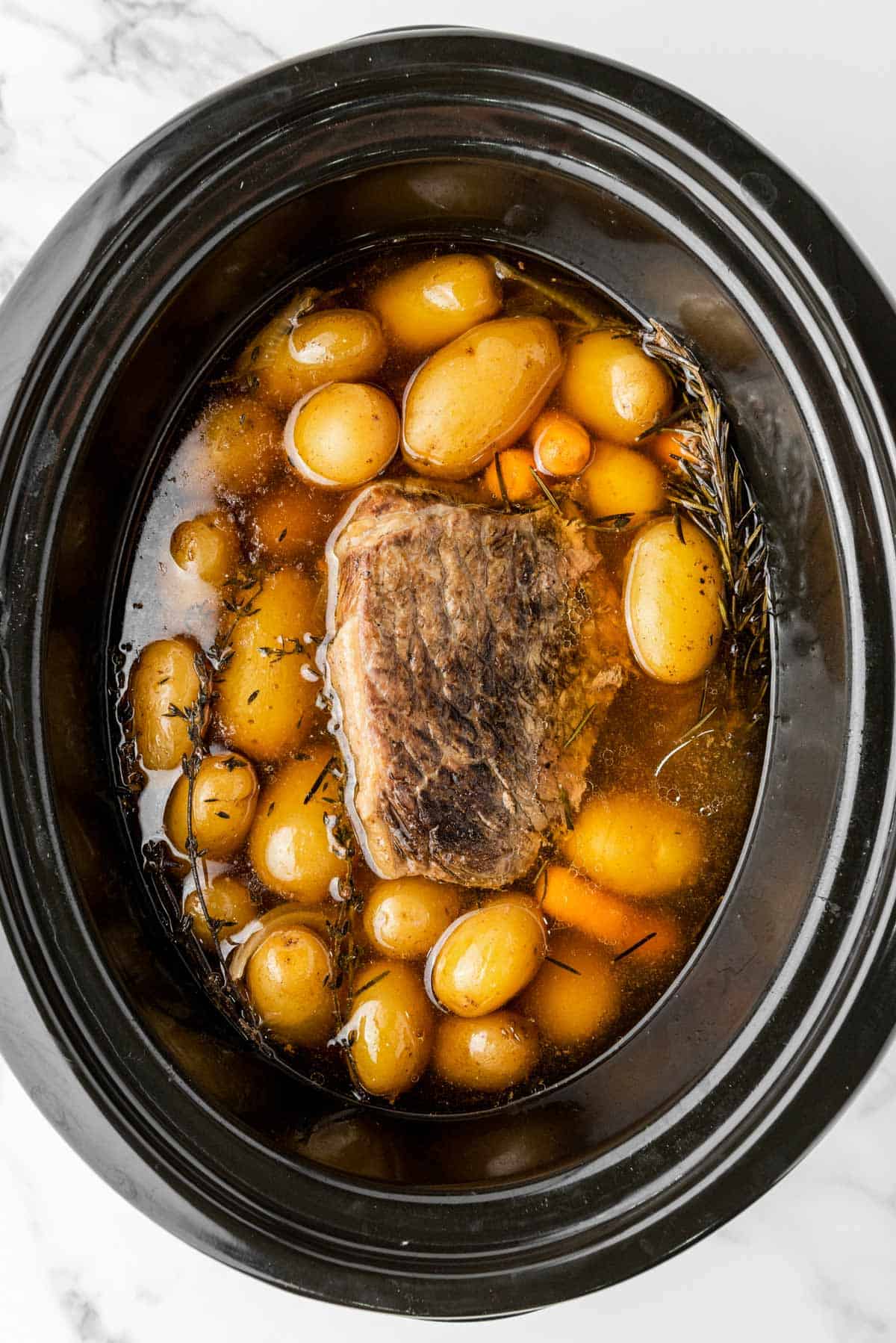 cooked rump roast with vegetables in slow cooker