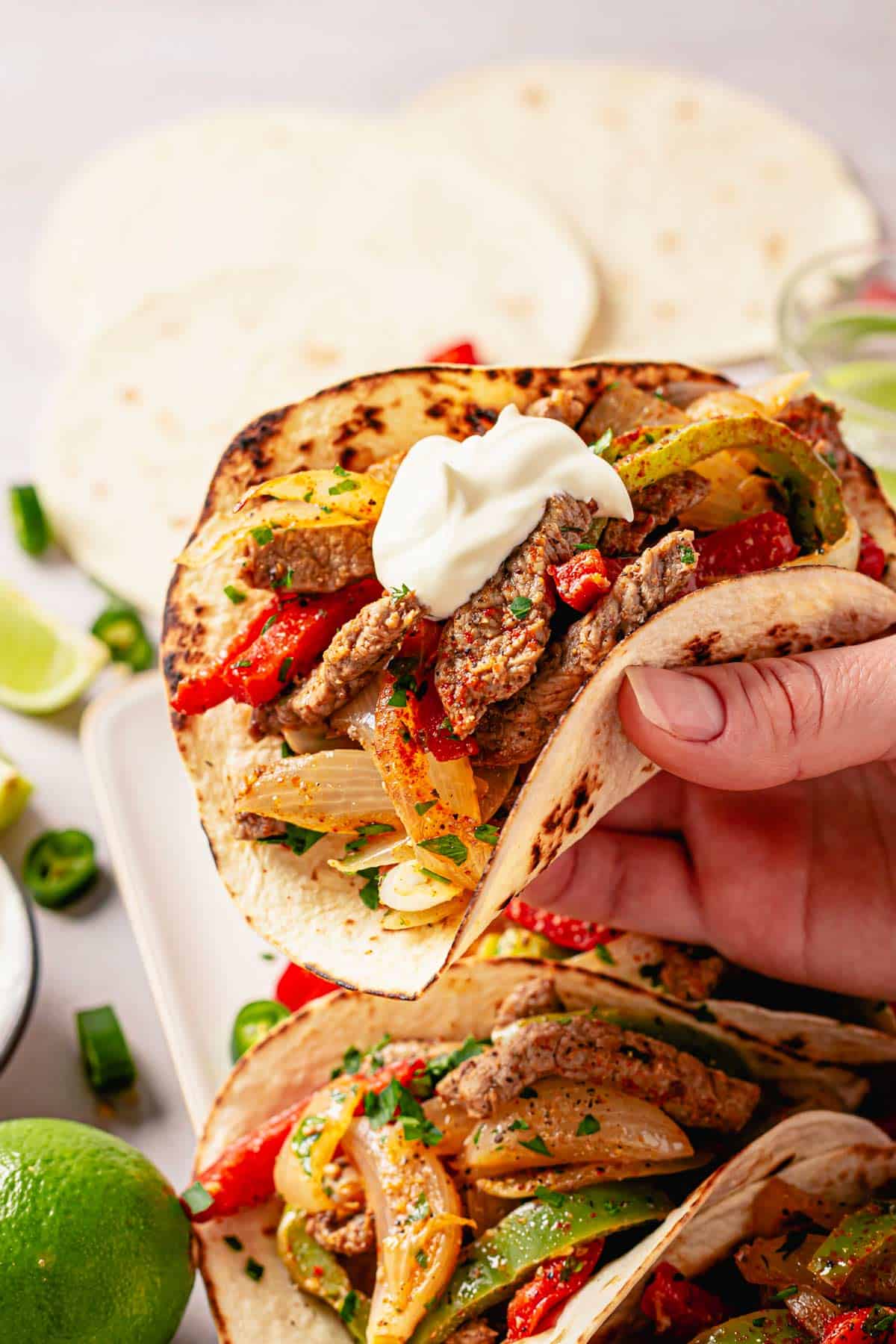 close up shot of steak fajita taco with sour cream