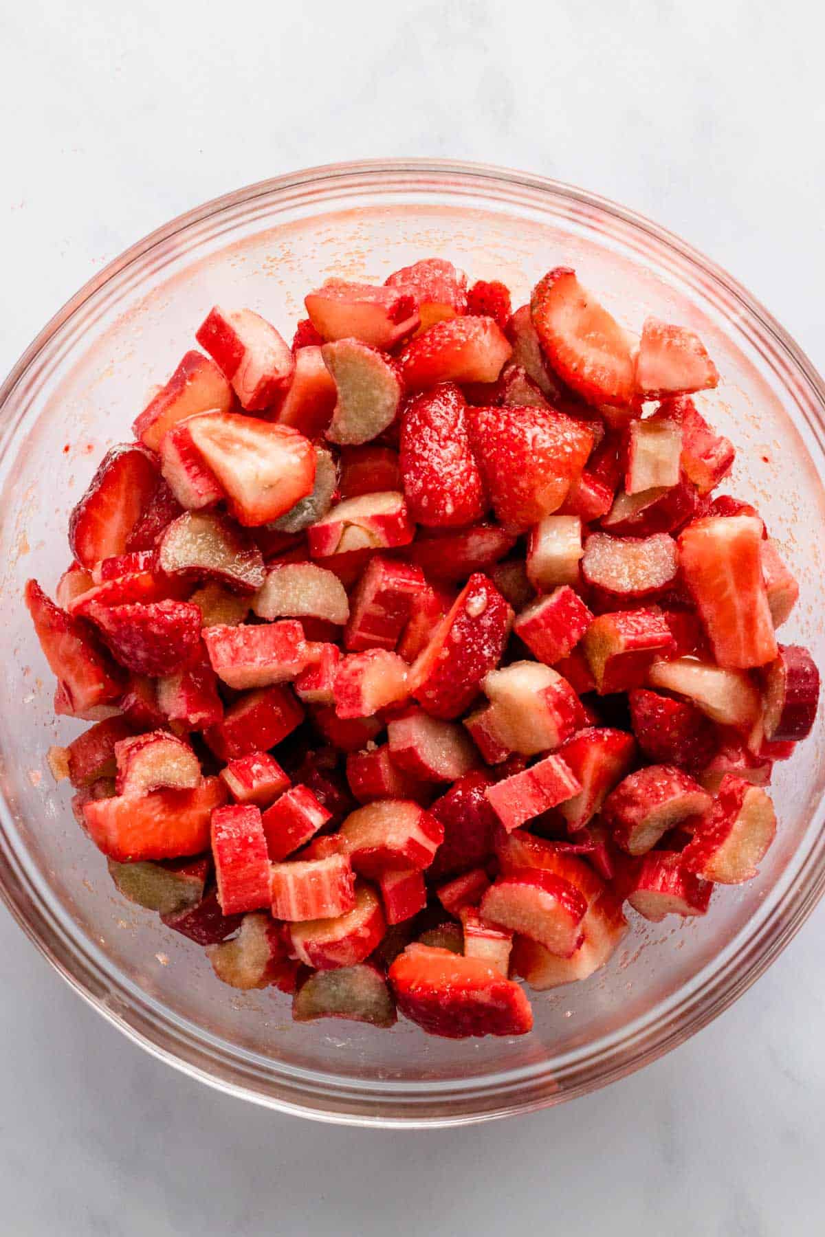 fresh strawberries and rhubarb in a bowl with cornstarch and flour